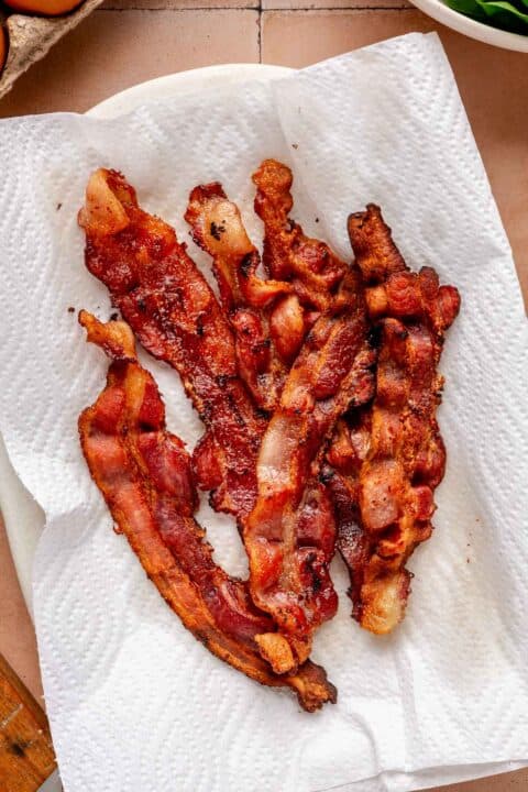 6 slices of crispy bacon on a paper towel lined plate
