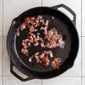 bacon frying in a cast iron skillet
