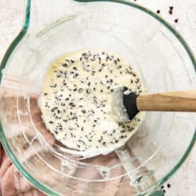 cream cheese mixture and mini chocolate chips in a clear stand mixer bowl with spatula