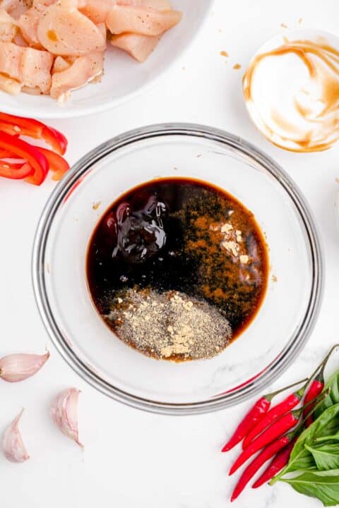 soy sauce, oyster sauce, fish sauce, brown sugar, pepper, and ginger in a clear bowl