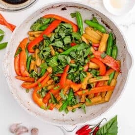 fresh thai basil and green onions are added to the nonstick skillet along with other vegetables