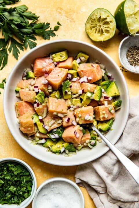 cubed salmon, avocado, and onions mixed together in a white bowl