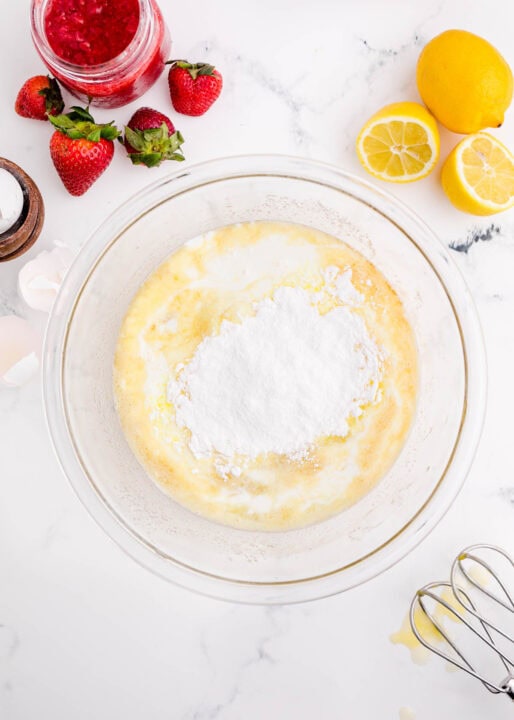 dry ingredients are added to a clear bowl along with wet ingredients