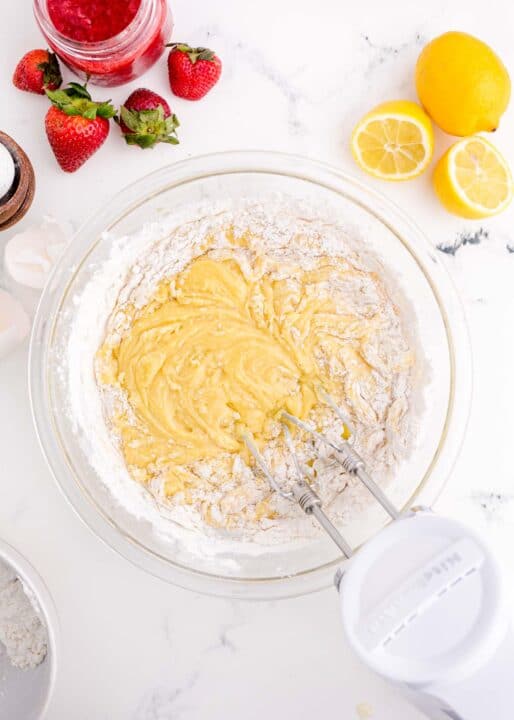 an electric mixer is mixing together batter in a clear bowl