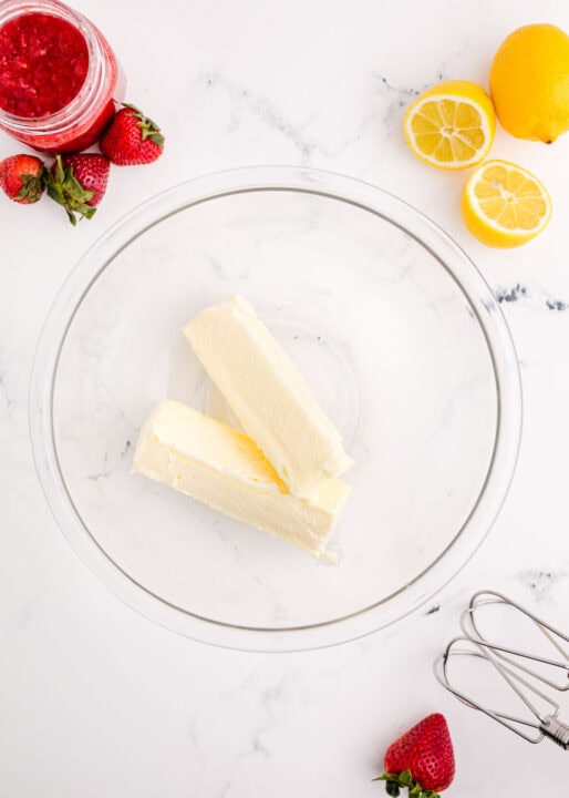 two sticks of room temperature butter in a clear bowl
