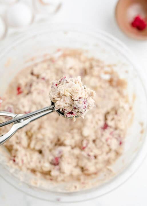 a scoop of white chocolate raspberry cookie dough in a metal cookie scoop
