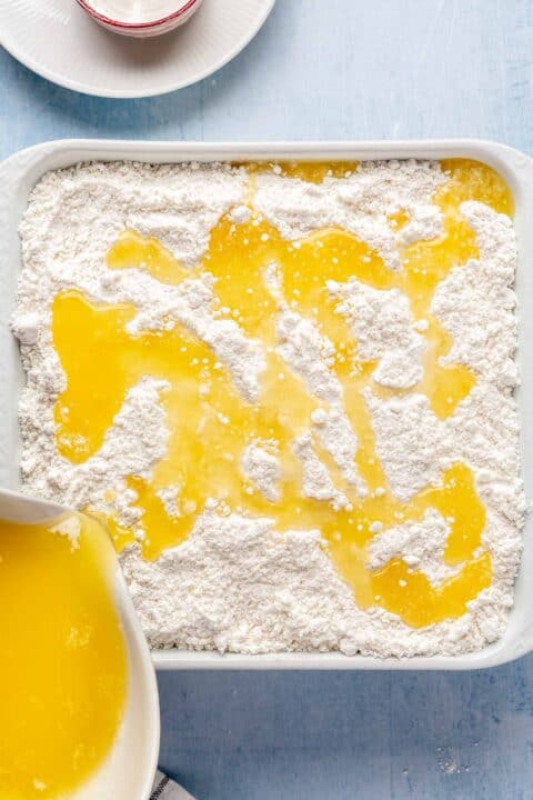 melted butter being poured on top of cake mix