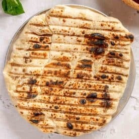 charred and browned pizza dough on a metal pizza pan