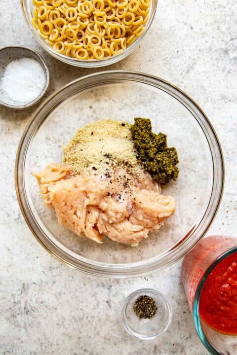 ground chicken, pesto, panko breadcrumbs, salt and pepper in a clear bowl