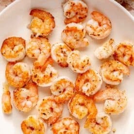 shrimp being cooked in a skillet until browned and crispy