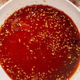 honey garlic sauce thickening in a white skillet