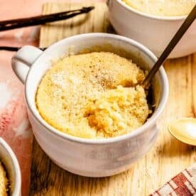 a good spoon has scooped out a quarter of the vanilla cake in the mug